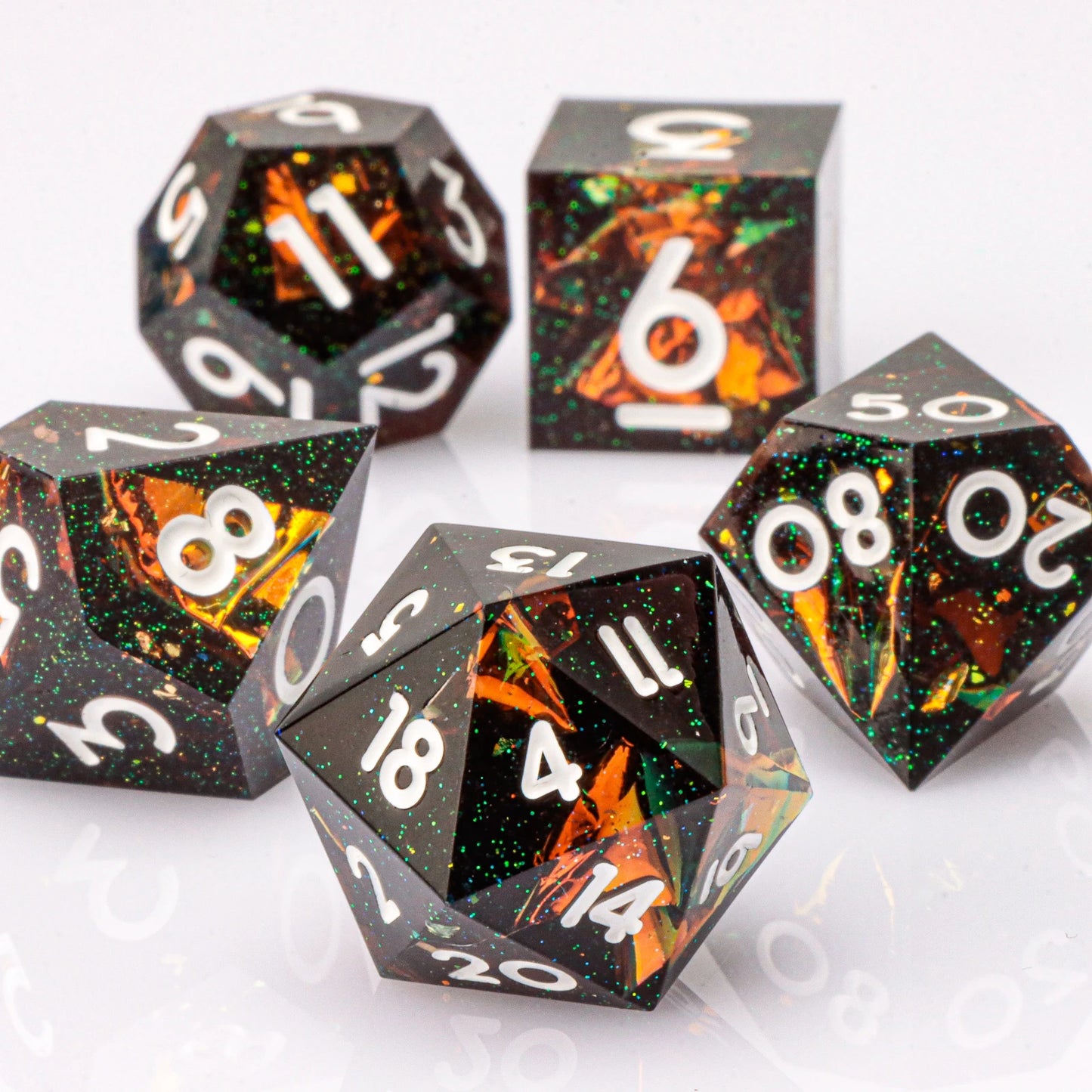 Set of polyhedral dice with black, orange, and white design on a white background