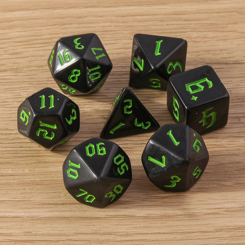 Black dice with green numbers on a wooden surface