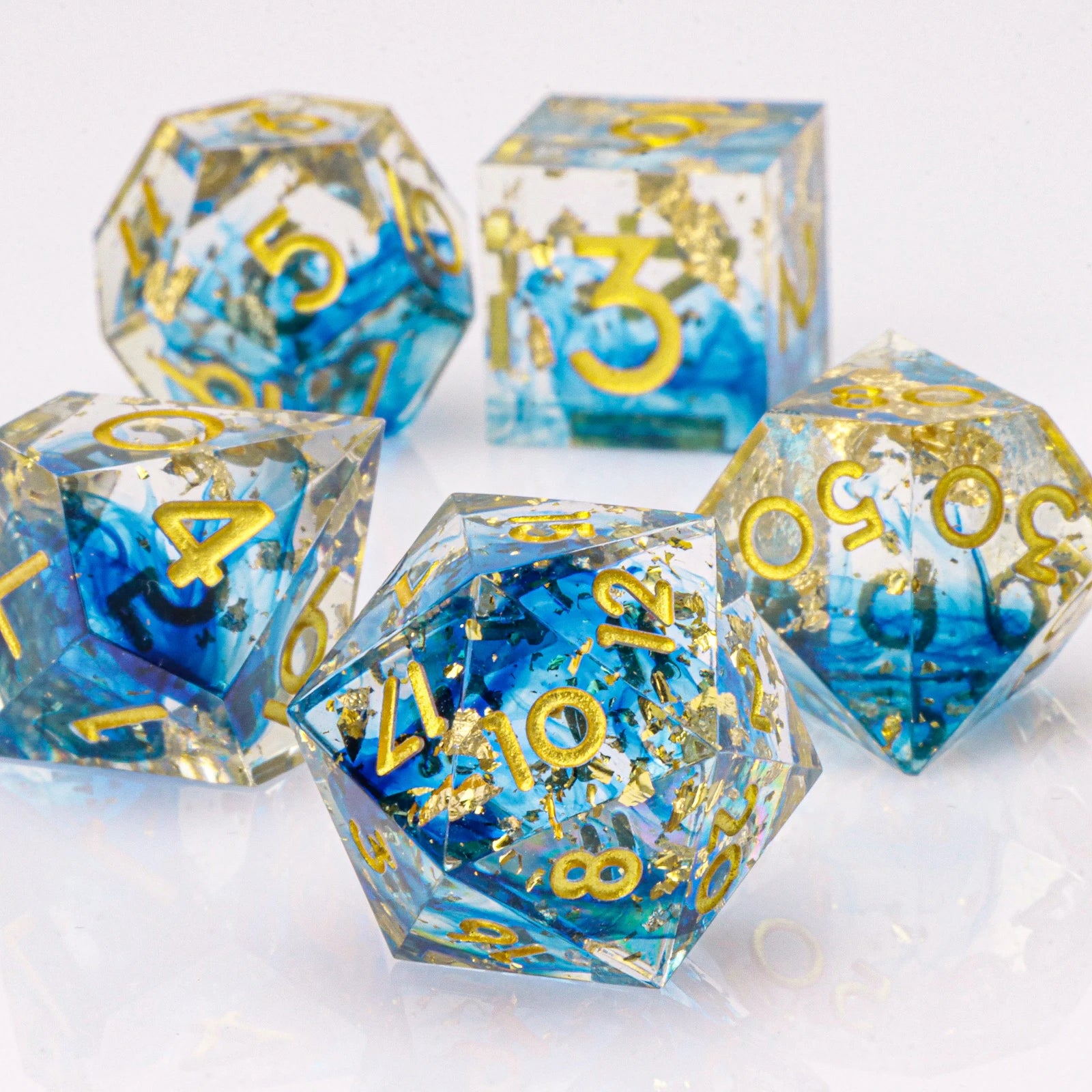Set of blue and clear dice with gold numbers on a white background