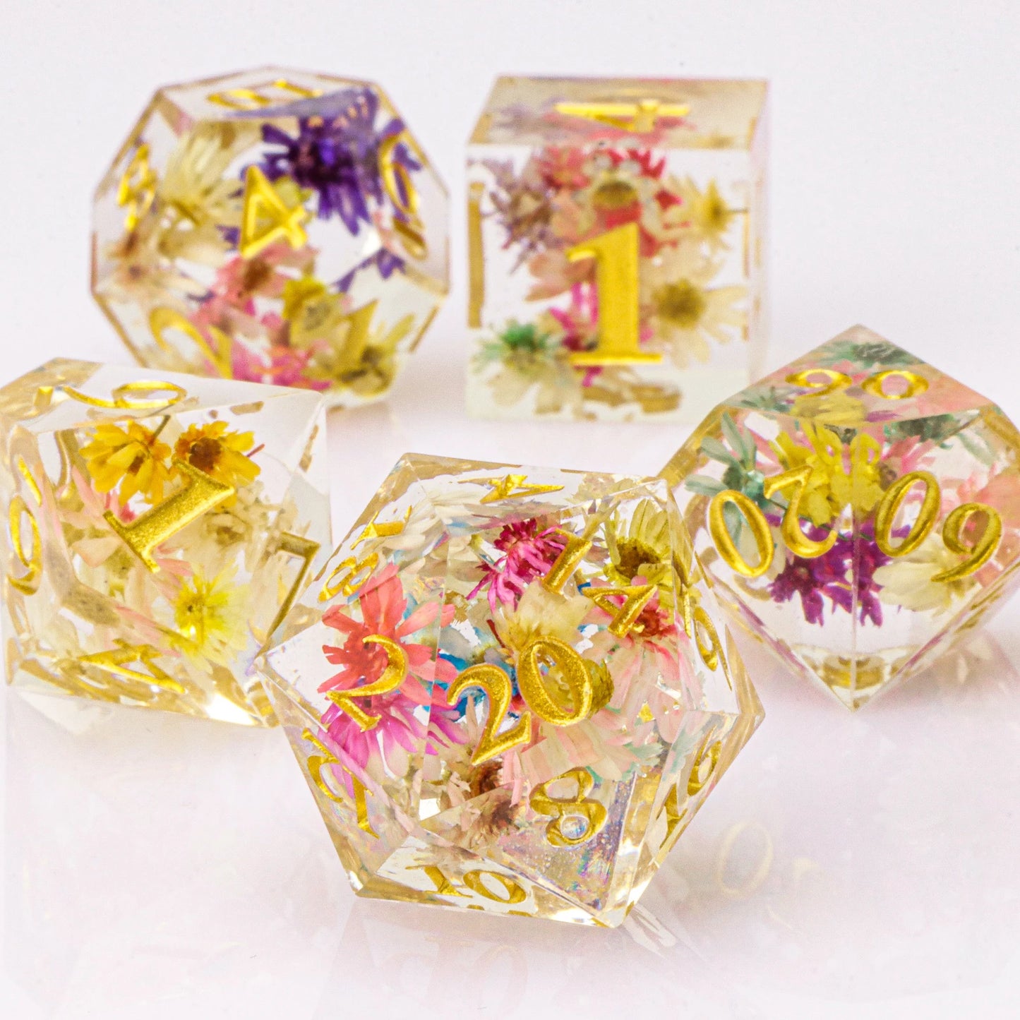 Translucent dice with floral embeddings and gold numbers on a white background