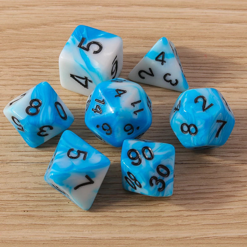 Set of blue and white dice with black numbers on a wooden surface