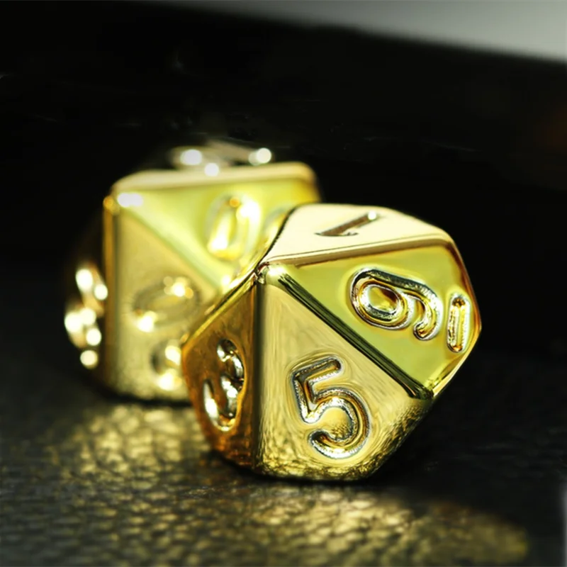 Two gold polyhedral dice on a dark surface