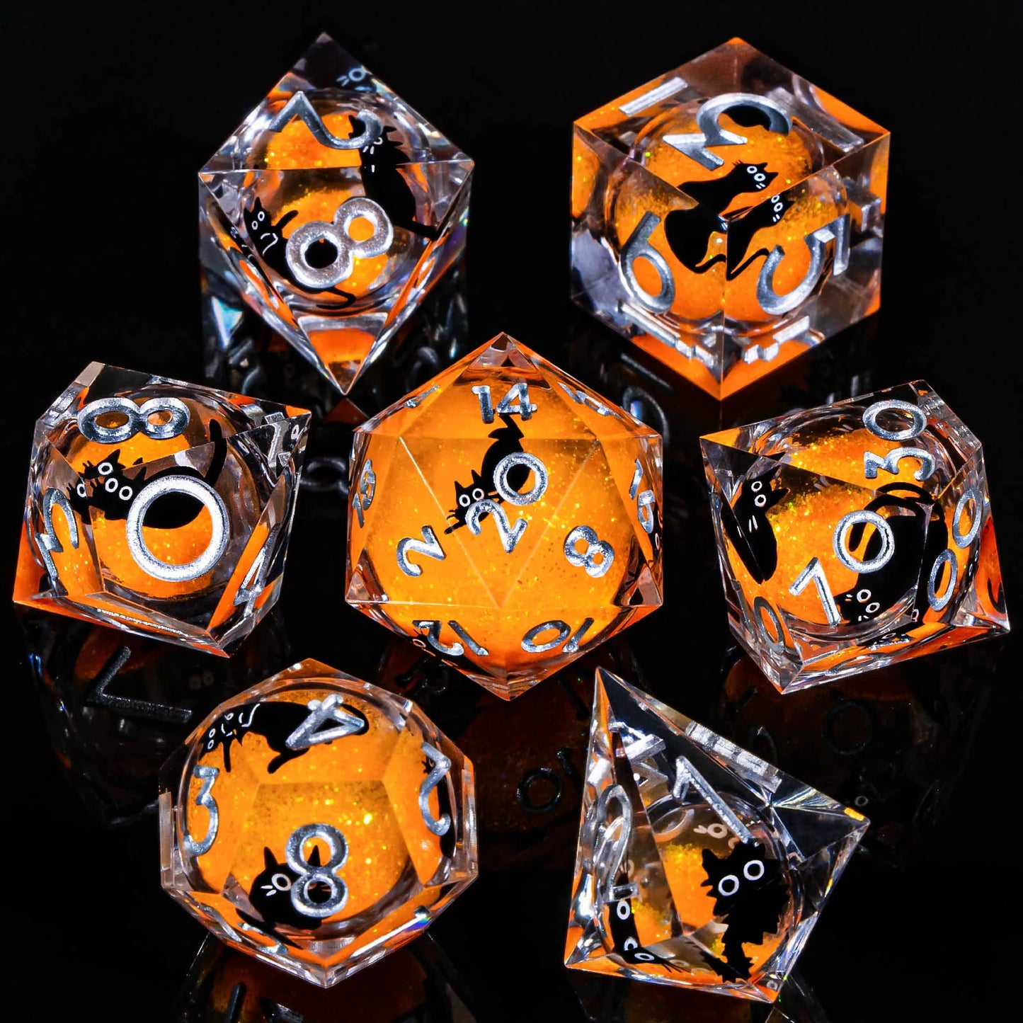 A set of transparent acryilic dice with an orange glitter and cartoon cat liquid core, and silver numbering.