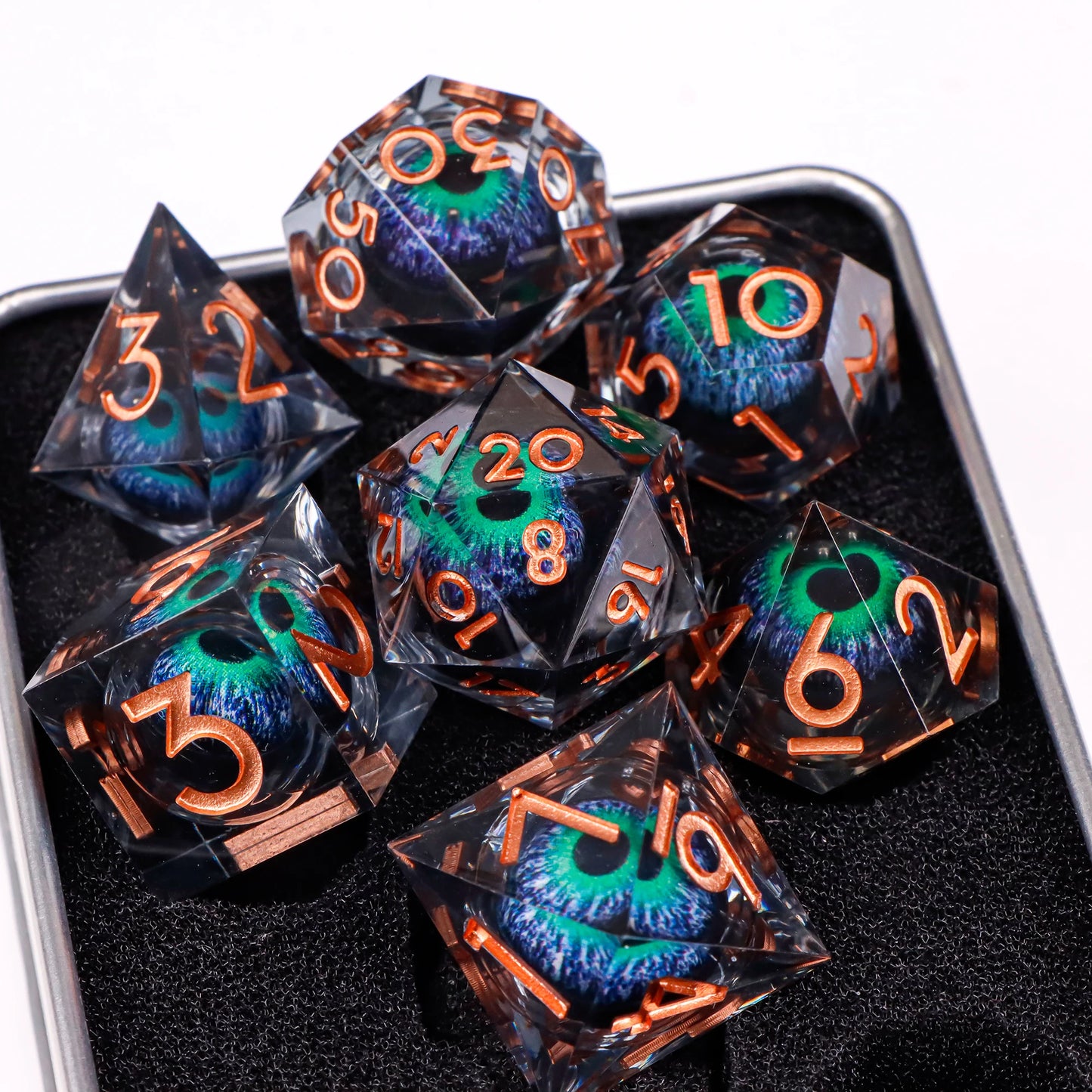 A set of translucent ttrpg dice with copper numbering. Inside each die there is a liquid core, containing a blue and green eye staring upwards.