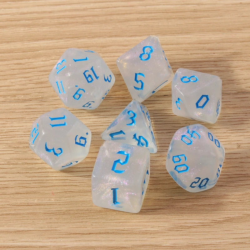 Set of clear dice with blue numbers on a wooden surface