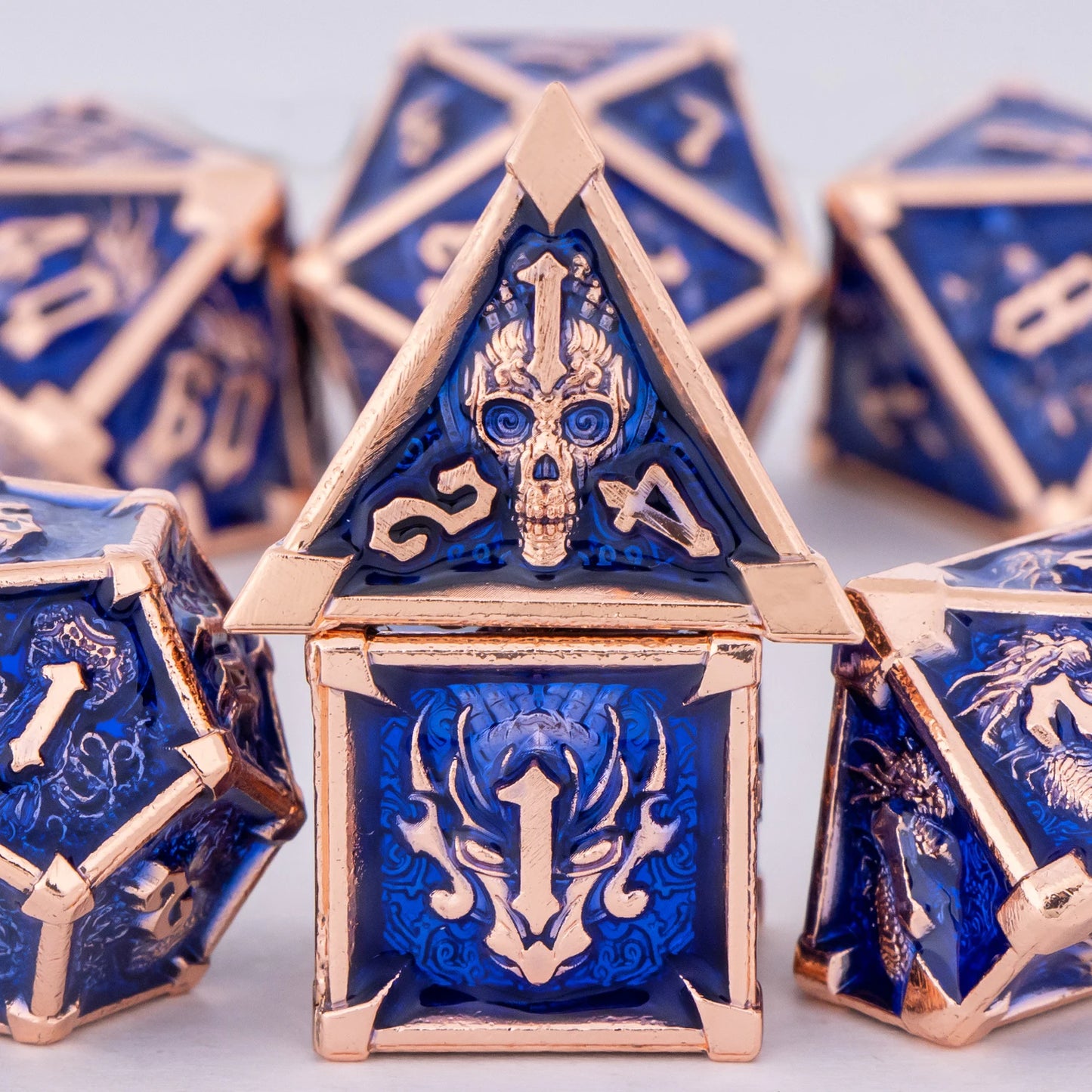 Blue and gold polyhedral dice set on a light background