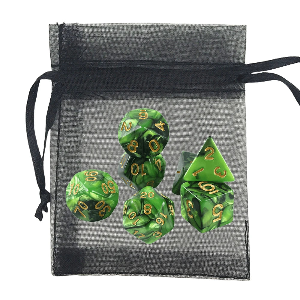 Green marbled polyhedral dice with gold numbers displayed in front of a black sheer drawstring bag on a white background.