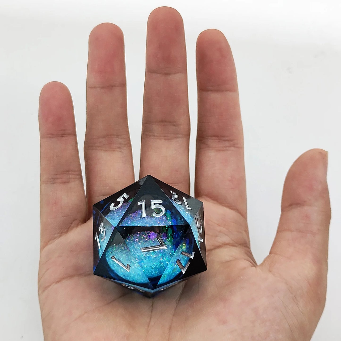 D20 polyhedral dice held in a hand against a white background
