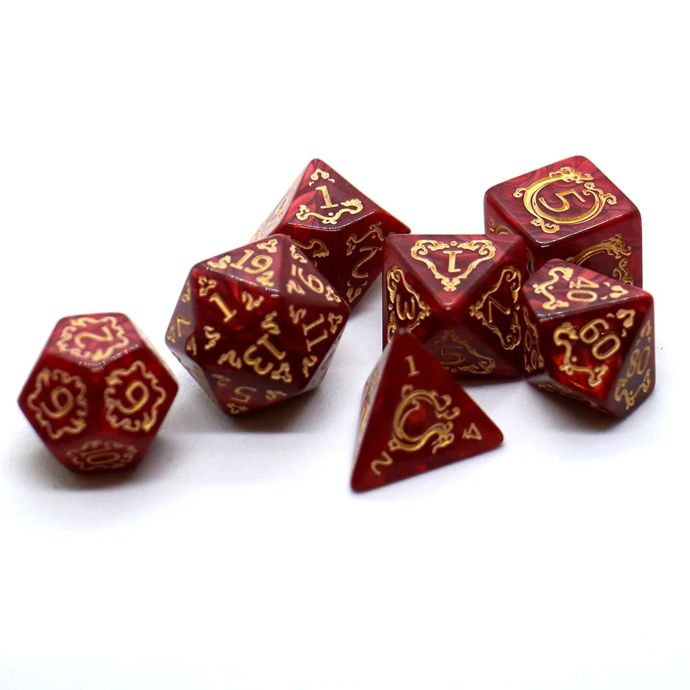 Set of red polyhedral dice with gold numbering on a white background