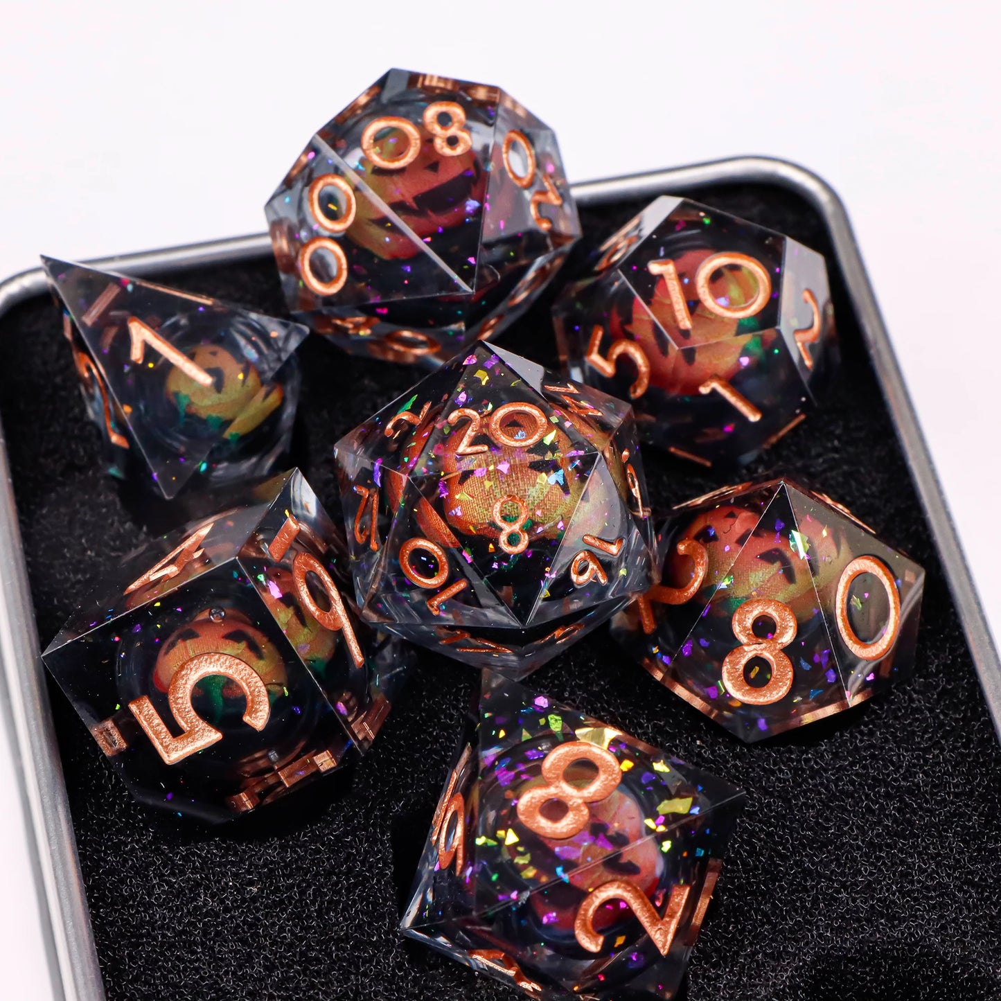 A set of translucent ttrpg dice with rose gold numbering and rainbow glitter. Inside each die there is a liquid core, containing a fantasy eye staring upwards.