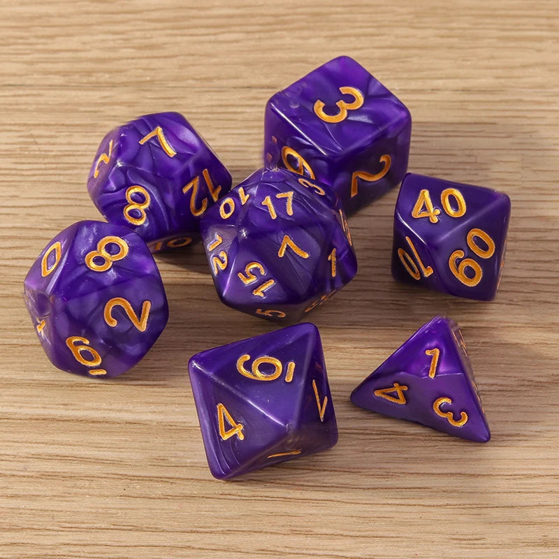 Purple polyhedral dice with gold numbers on a wooden surface