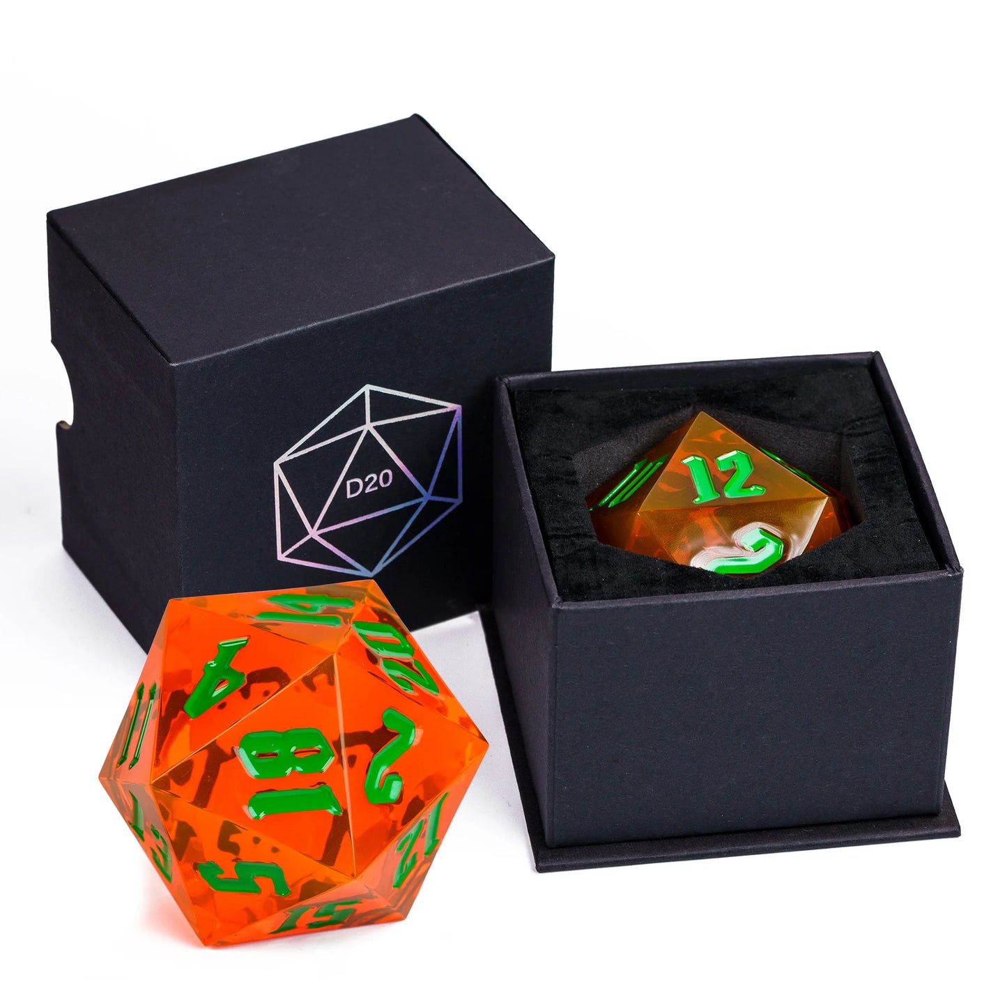 A translucent orange D20 polyhedral die with bright green numbering, shown alongside a black presentation box with a matching D20 icon and a second box containing a translucent amber D20 die with green numbering.
