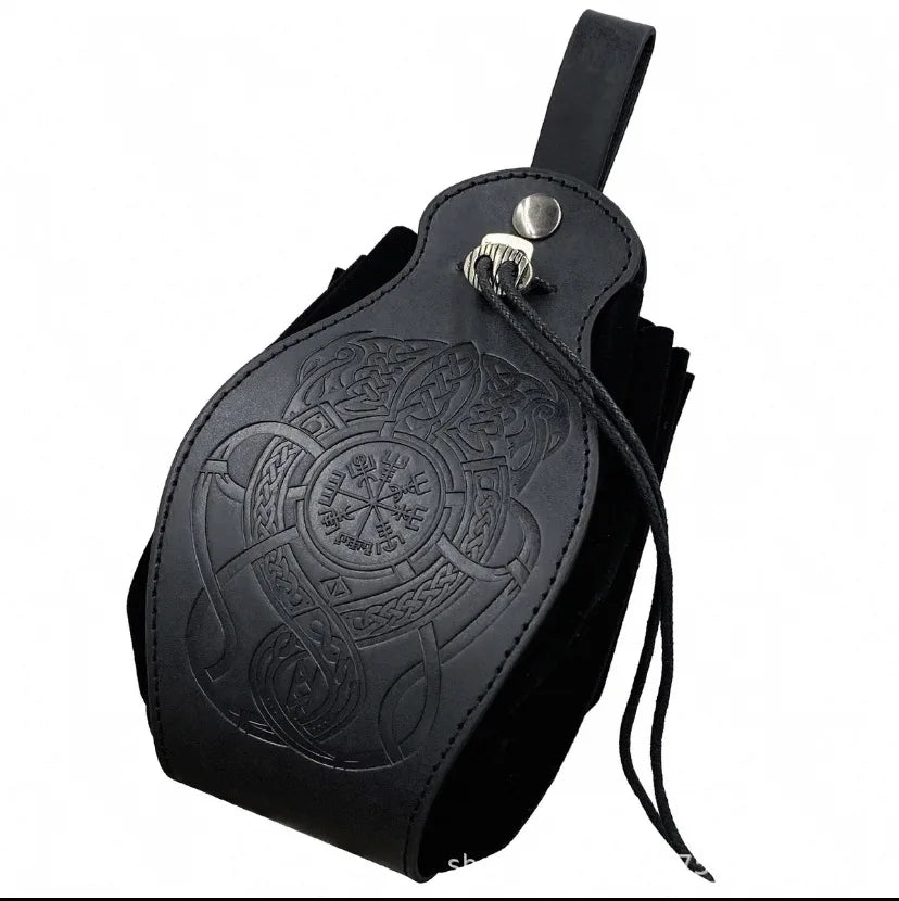 Black leather pouch with embossed Celtic knotwork and Norse wheel designs, featuring a metal snap closure and a hanging drawstring on a white background.