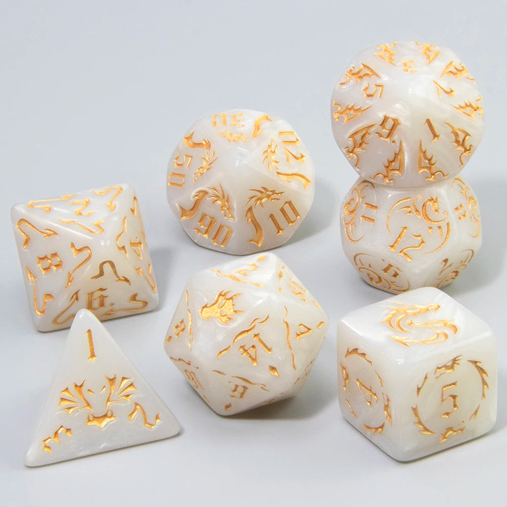 A set of seven white polyhedral gaming dice with engraved gold symbols, arranged on a light gray studio background.