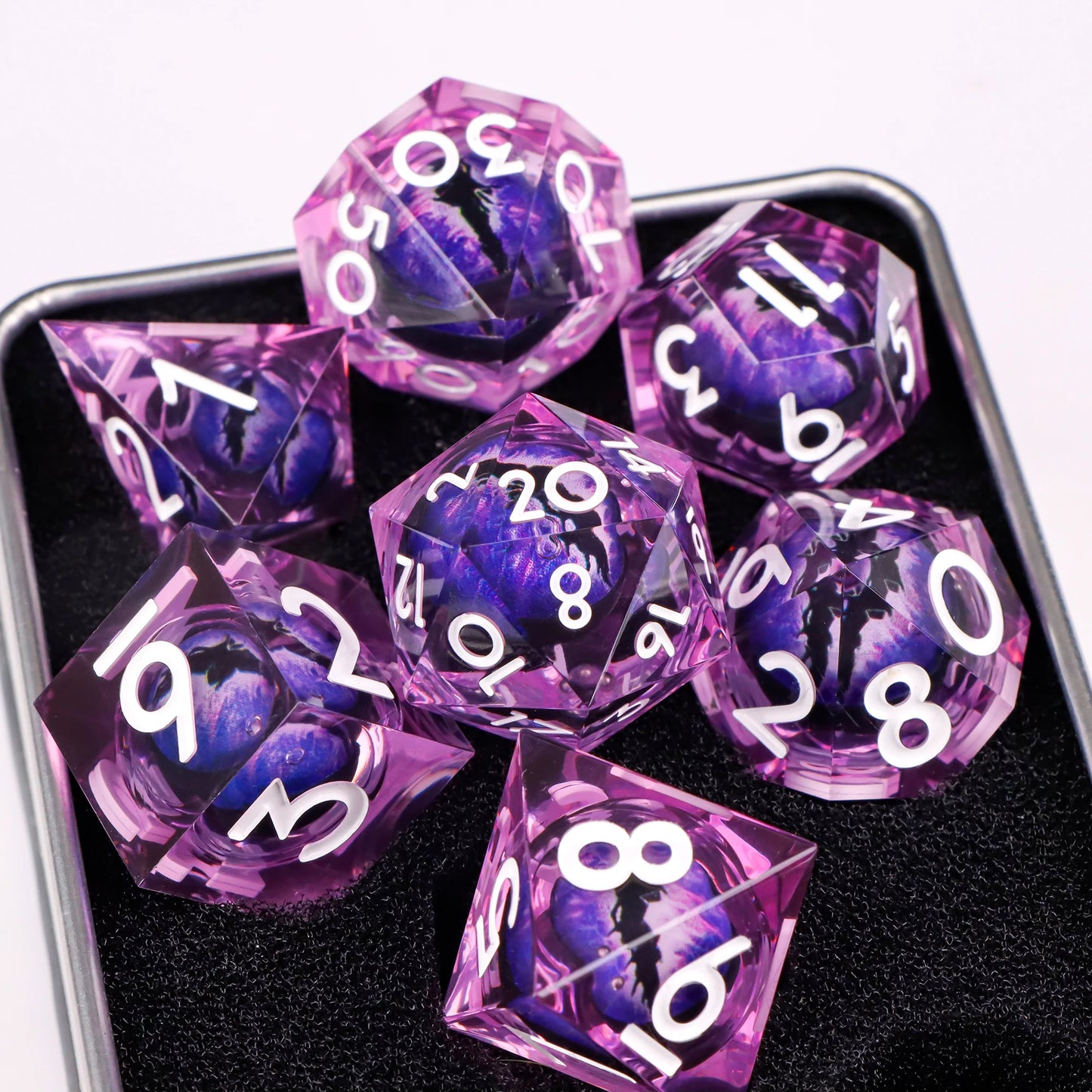 A set of purpletranslucent ttrpg dice with white numbering. Inside each die there is a liquid core, containing a fantasy eye staring upwards.