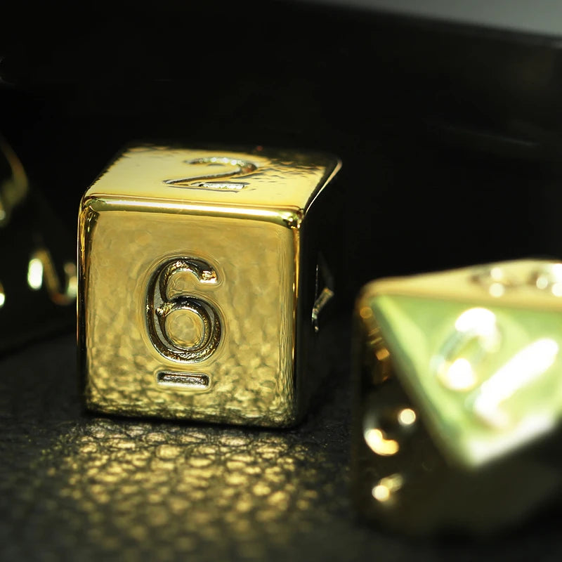Gold dice with the number 6 on a dark surface
