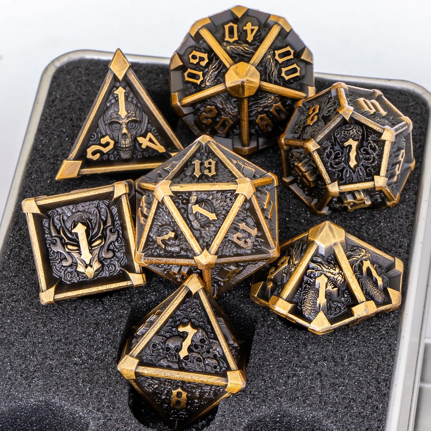 Set of ornate polyhedral dice with gold and black design on a gray background