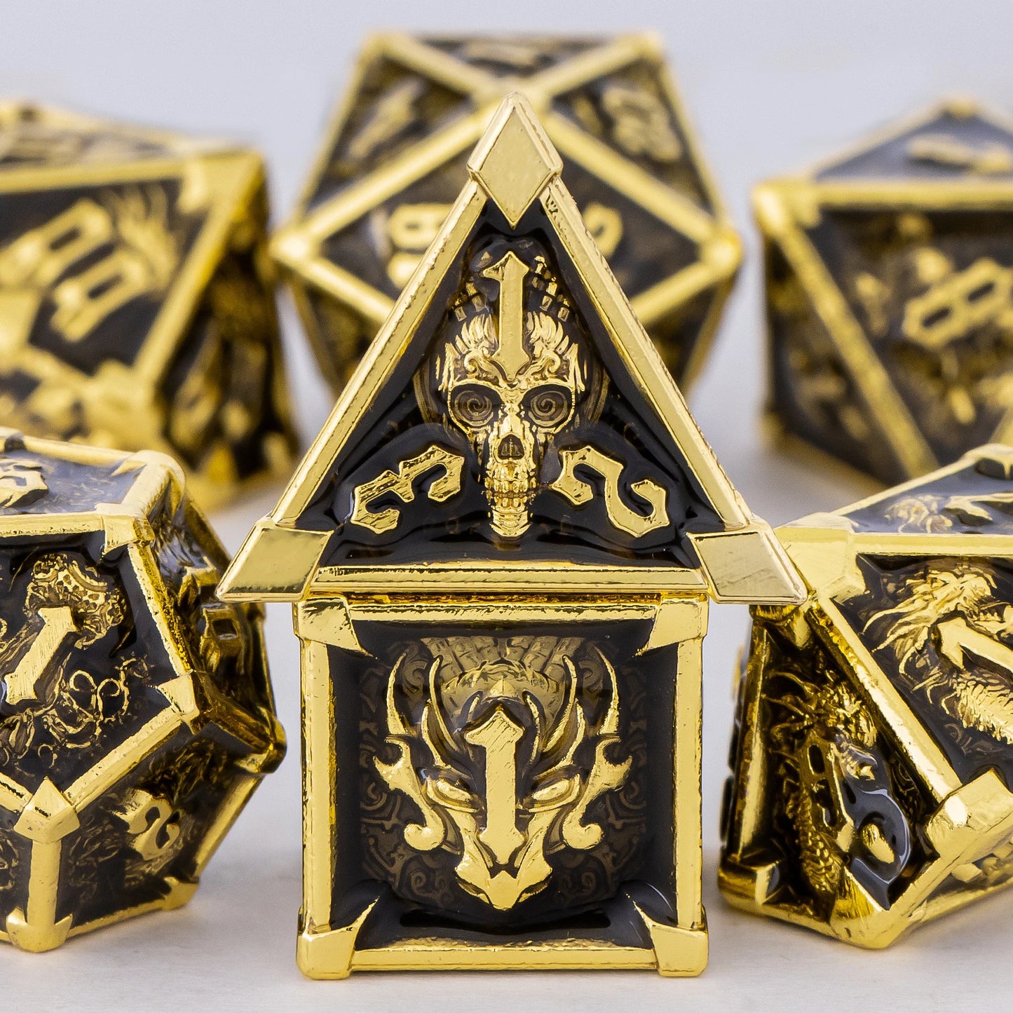 Gold and black polyhedral dice set on a light gray background