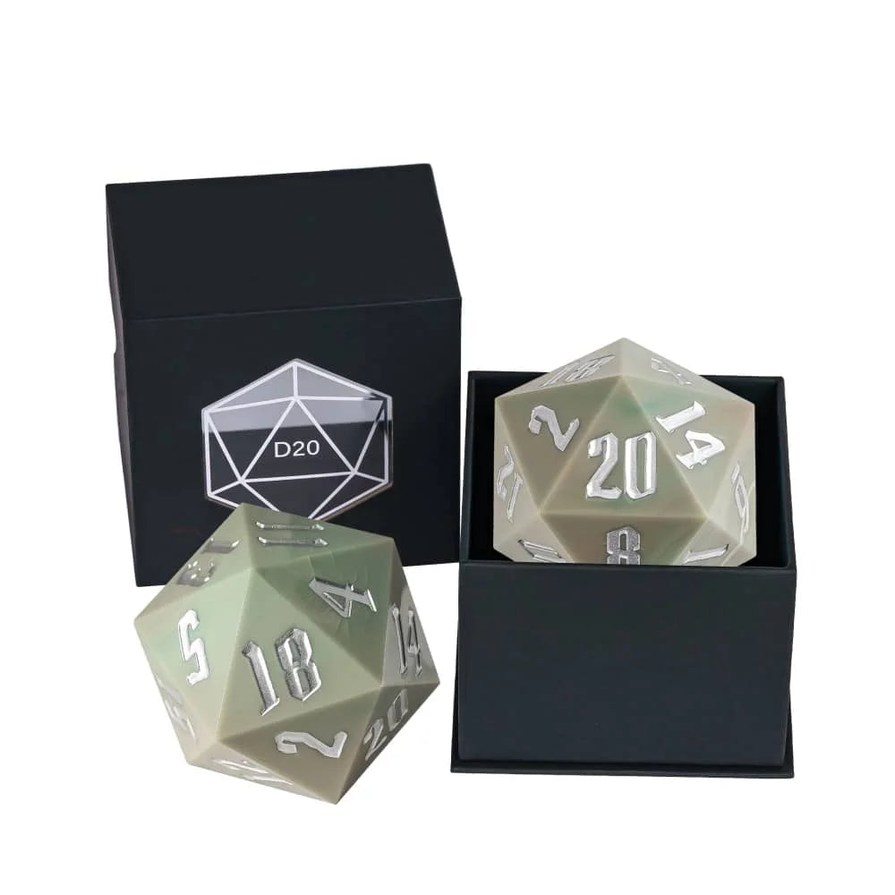 A d20 dice in a muted sage green color with white numbering, shown with its black presentation box on a white background.