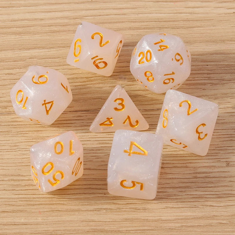 Set of translucent dice with gold numbers on a wooden surface