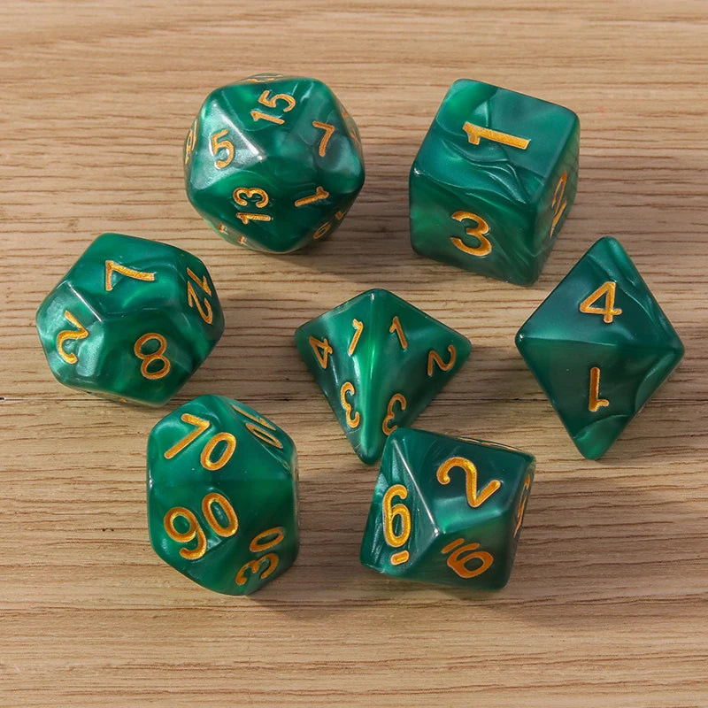 Set of green polyhedral dice with gold numbers on a wooden surface
