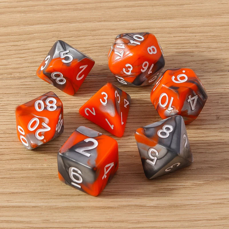 Set of orange and gray polyhedral dice on a wooden surface