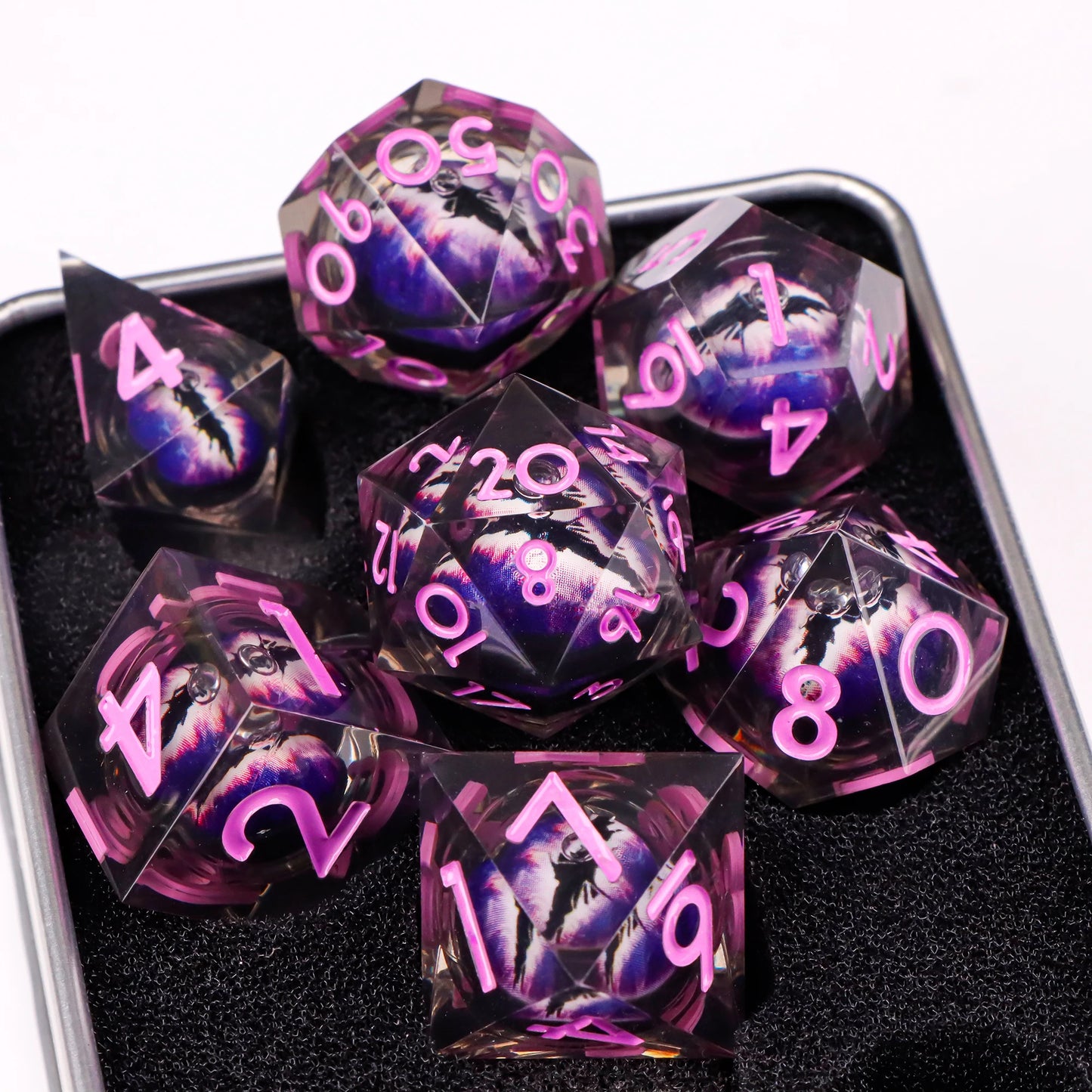 A set of translucent ttrpg dice with pink numbering. Inside each die there is a liquid core, containing a fantasy eye staring upwards.