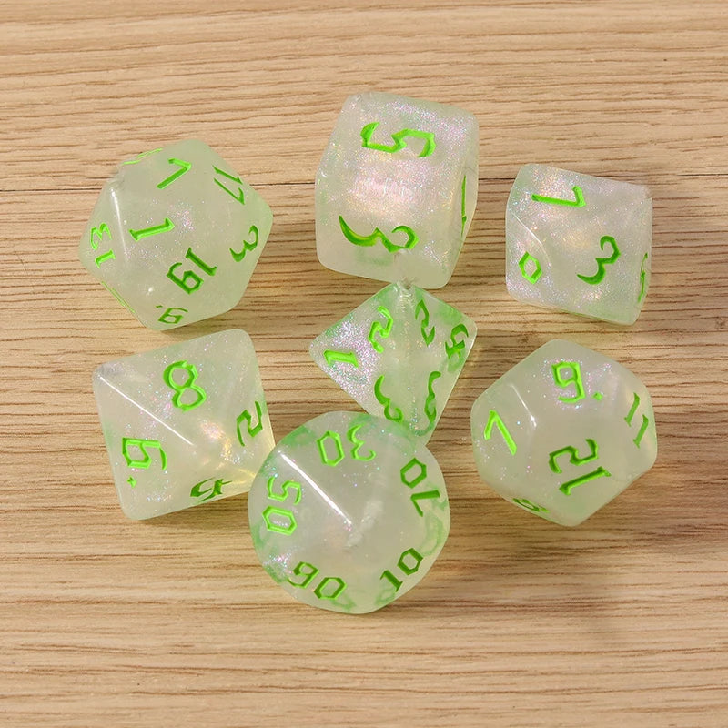 Set of translucent dice with green numbers on a wooden surface