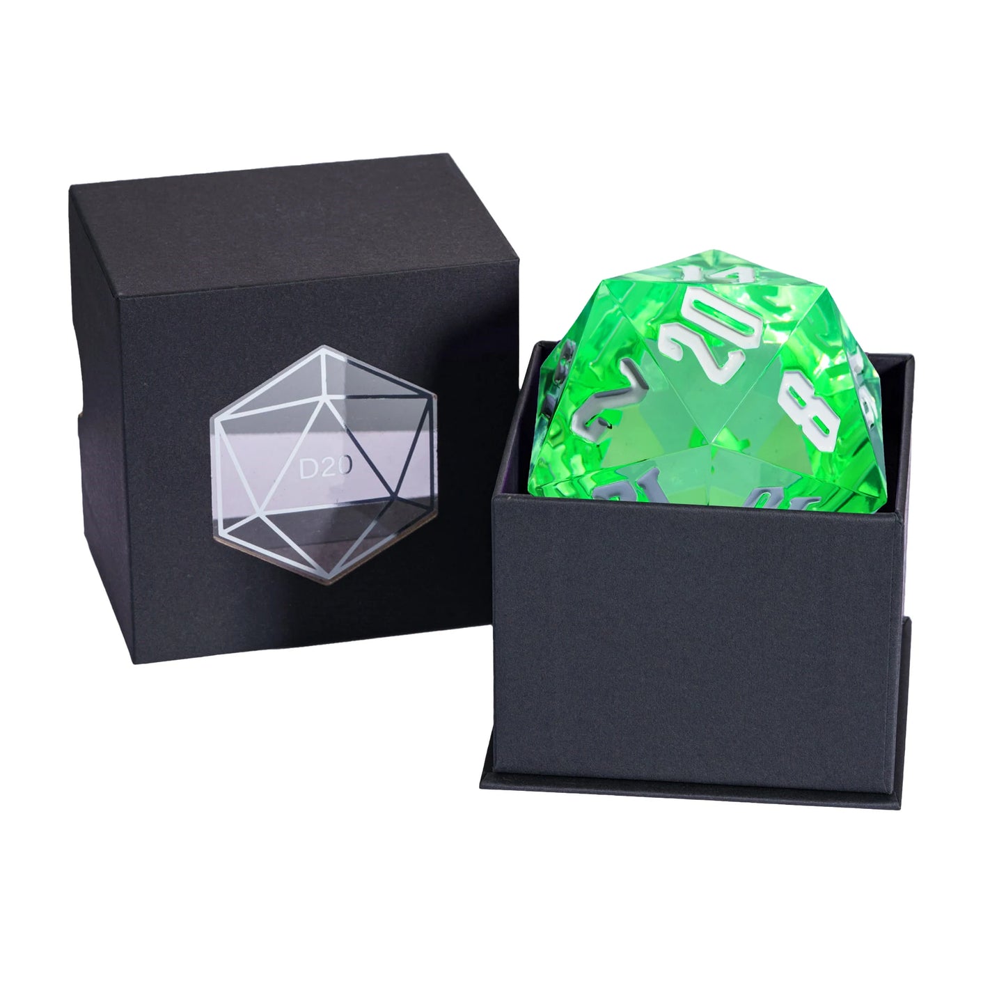 A translucent neon green d20 die with white numbering next to its black presentation box, with the matching black lid showing an engraved clear 20-sided icon on a white background.