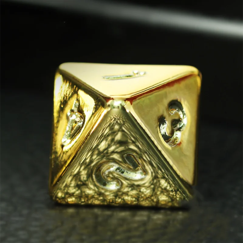 Gold dice with intricate design on a dark background