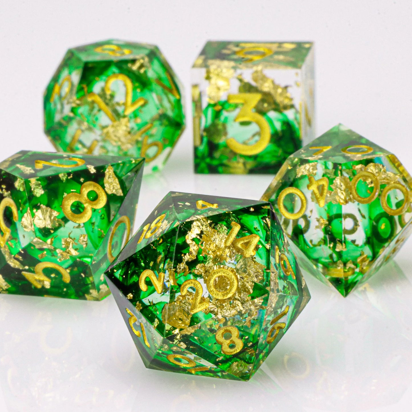 Green and gold polyhedral dice set on a white background
