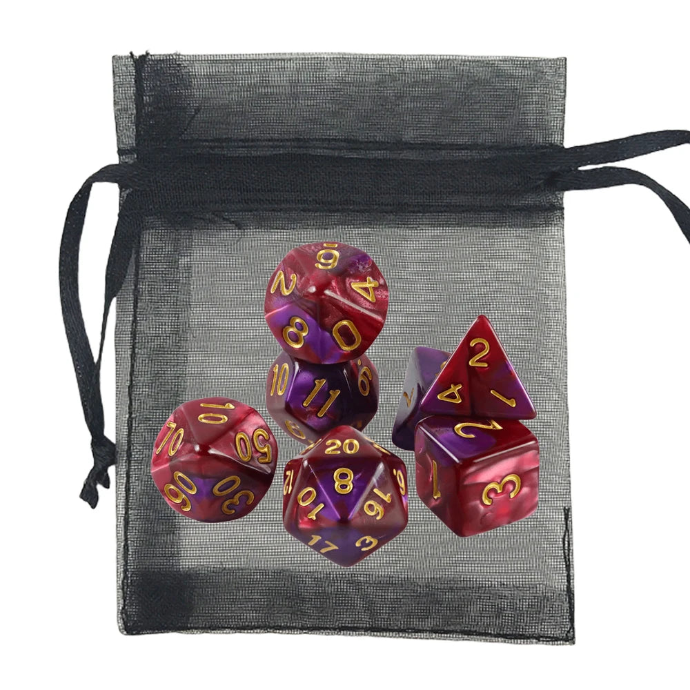 A set of polyhedral dice with a metallic red and purple gradient finish and gold numbers, displayed next to a black sheer drawstring bag on a white background.
