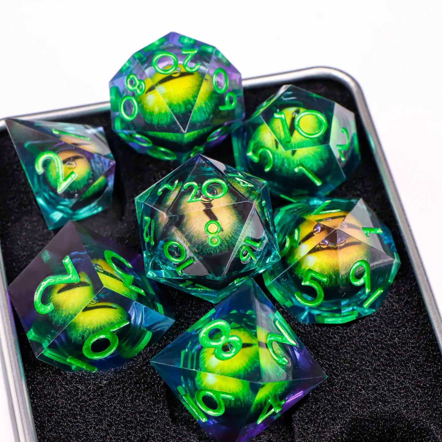 A set of blue-green translucent ttrpg dice with green numbering. Inside each die there is a liquid core, containing a fantasy eye staring upwards.