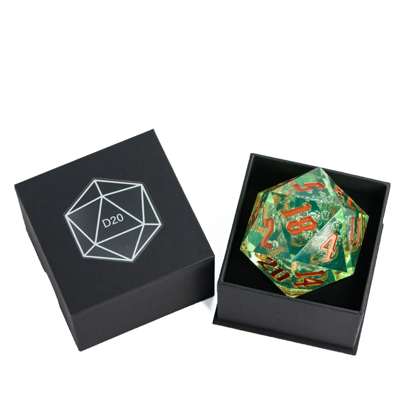 A green translucent 20-sided d20 polyhedral die with dark gold / orange printed numbers, displayed inside an open black gift box next to its closed lid which features a white geometric D20 logo.