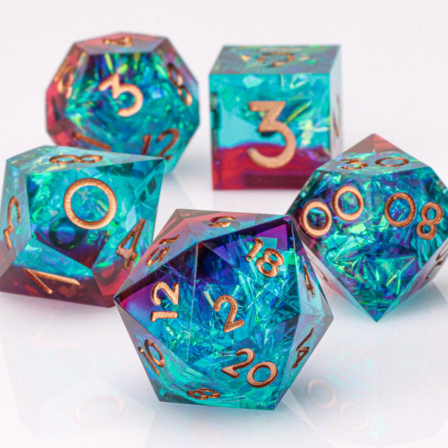 Set of colorful polyhedral dice with metallic numbers on a white background