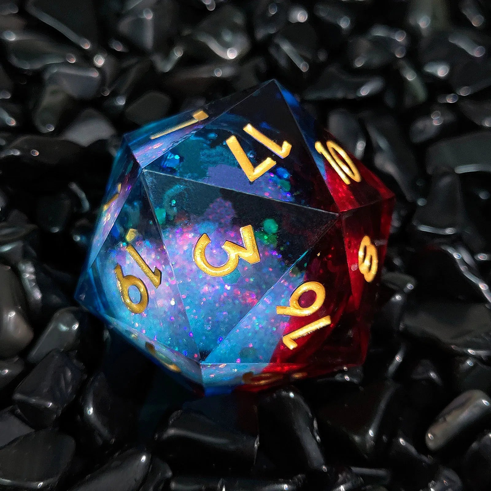 Multicolored polyhedral dice with gold numbers on a black textured background
