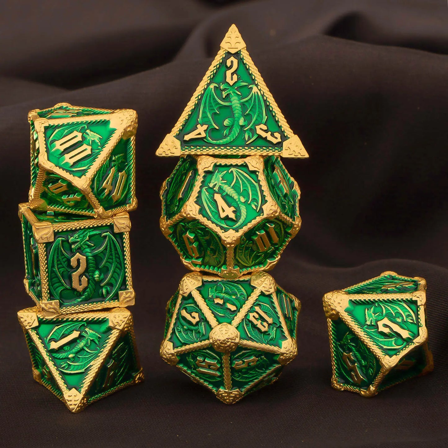 A set of green and gold fantasy polyhedral gaming dice arranged on a dark draped fabric background. The set includes a d4, d6, d8, d10, d%, d12, and d20,  with detailed dragon motifs and gold-colored edges and numbering.