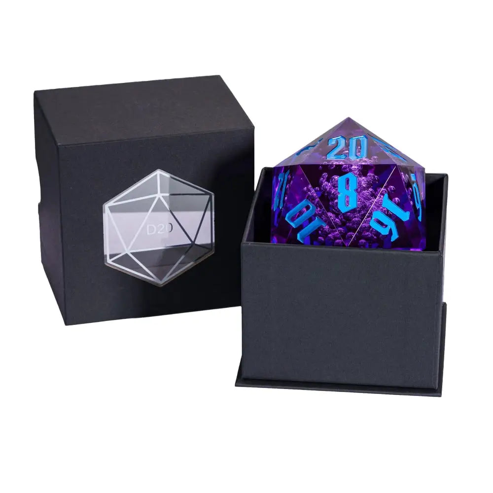 A transparent purple 20-sided die with blue numerals displayed inside a black presentation box, with the matching black lid shown beside it on a white background.